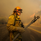 A firefighter watches a wildfire burning. (AP/Ringo H.W. Chiu)